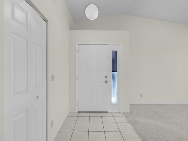 foyer with light carpet and vaulted ceiling