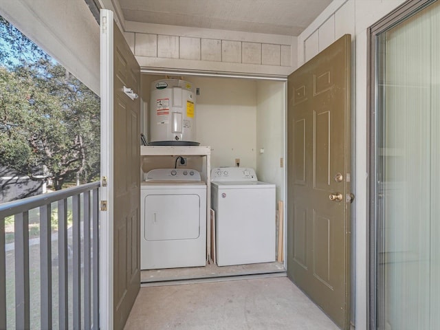 clothes washing area with water heater, a wealth of natural light, and washing machine and clothes dryer