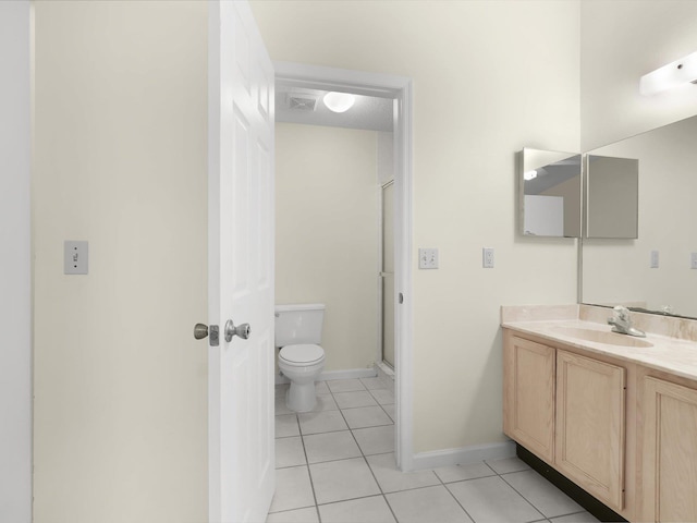 bathroom with toilet, vanity, tile patterned floors, and a shower with shower door