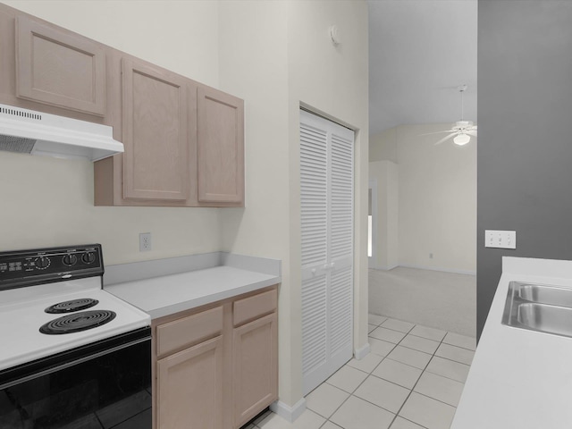 kitchen with white range with electric cooktop, light tile patterned flooring, sink, and light brown cabinetry