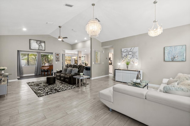 living area featuring lofted ceiling, baseboards, visible vents, and wood finished floors