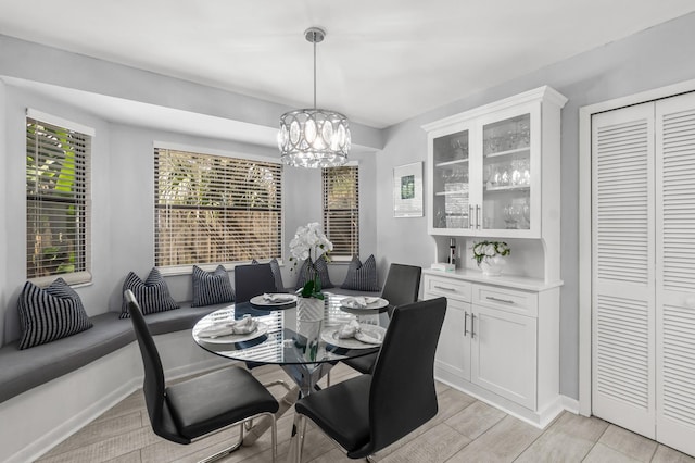 dining space with light wood finished floors and a chandelier