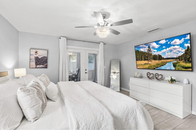 bedroom with light wood-type flooring, ceiling fan, visible vents, and baseboards