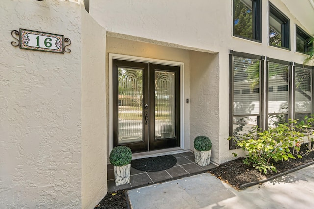 entrance to property featuring french doors and stucco siding