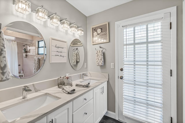 bathroom with double vanity, curtained shower, and a sink