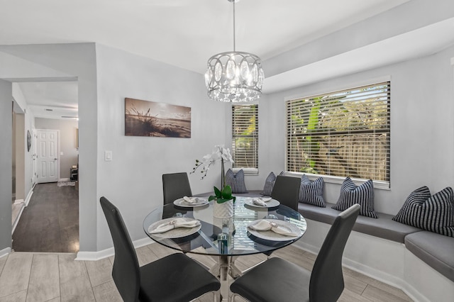 dining area featuring a chandelier, light wood-type flooring, and baseboards