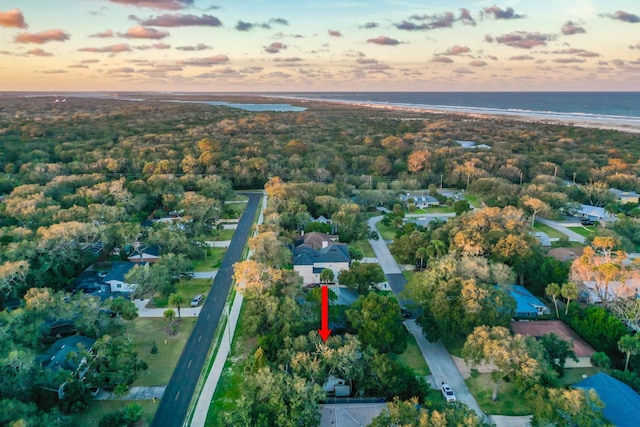 aerial view at dusk featuring a water view