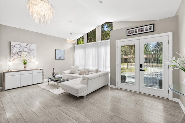 living room featuring a healthy amount of sunlight, light wood-style floors, and french doors