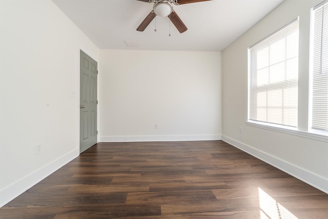 empty room with ceiling fan, dark wood-style flooring, and baseboards