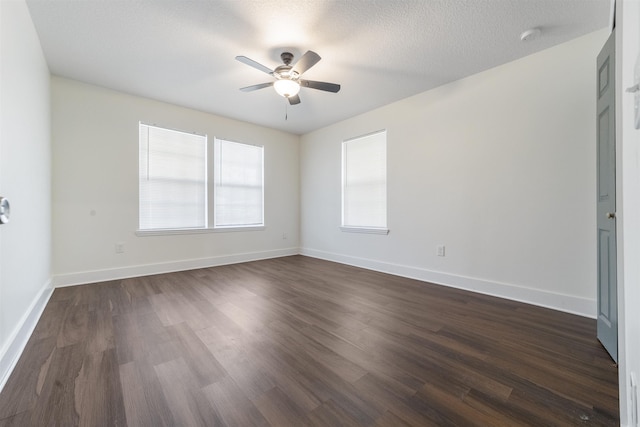 unfurnished room with baseboards, a textured ceiling, a ceiling fan, and dark wood-type flooring