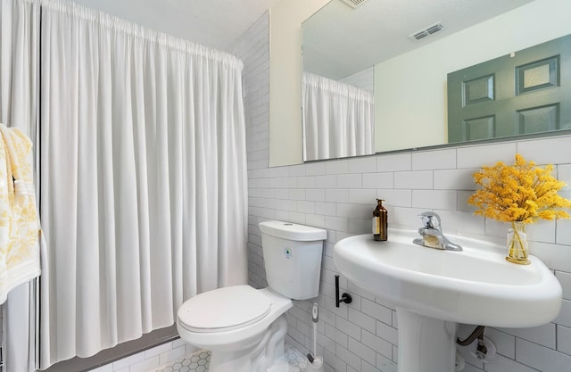 full bathroom featuring toilet, tile walls, visible vents, and a shower with curtain