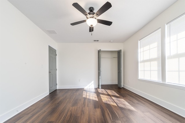 unfurnished bedroom featuring visible vents, dark wood finished floors, baseboards, and ceiling fan