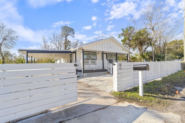 view of front of house with covered porch, a fenced front yard, a gate, and board and batten siding