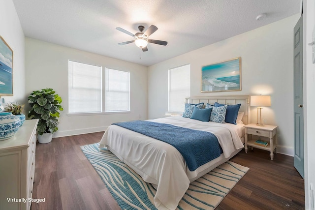 bedroom featuring a textured ceiling, baseboards, and wood finished floors