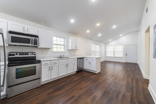 kitchen featuring lofted ceiling, a peninsula, a sink, light countertops, and appliances with stainless steel finishes