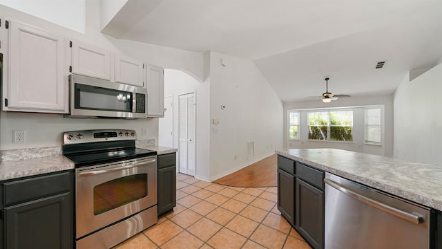2169 Saint Martins Dr, Jacksonville, FL 32246 - kitchen with appliances with stainless steel finishes, a ceiling fan, light countertops, light tile patterned floors, and white cabinetry