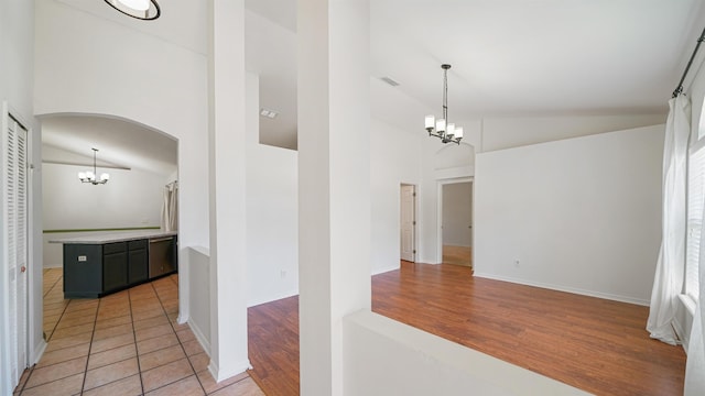 2169 Saint Martins Dr, Jacksonville, FL 32246 - corridor with a chandelier, arched walkways, high vaulted ceiling, and light wood finished floors