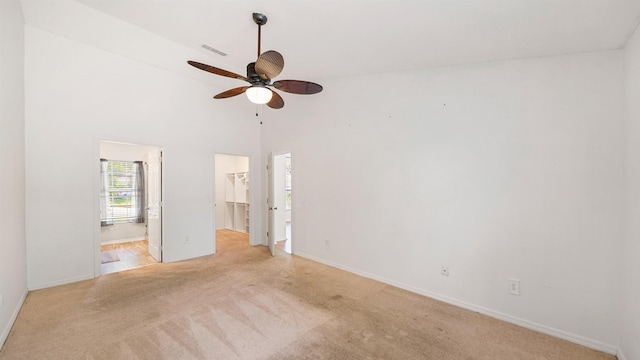 2169 Saint Martins Dr, Jacksonville, FL 32246 - unfurnished bedroom with a spacious closet, light carpet, a closet, connected bathroom, and a ceiling fan