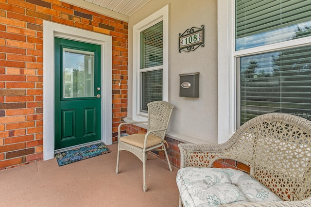 entrance to property with covered porch and brick siding