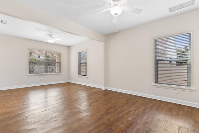 unfurnished room with visible vents, ceiling fan, baseboards, and wood finished floors