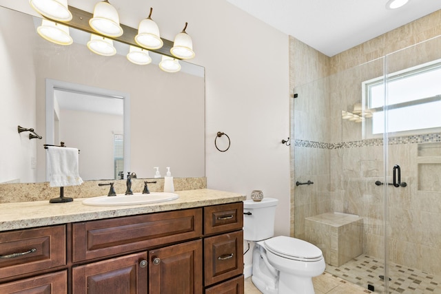 bathroom featuring toilet, a stall shower, and vanity