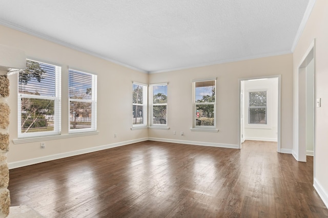 empty room featuring baseboards, a textured ceiling, ornamental molding, and dark wood-style flooring