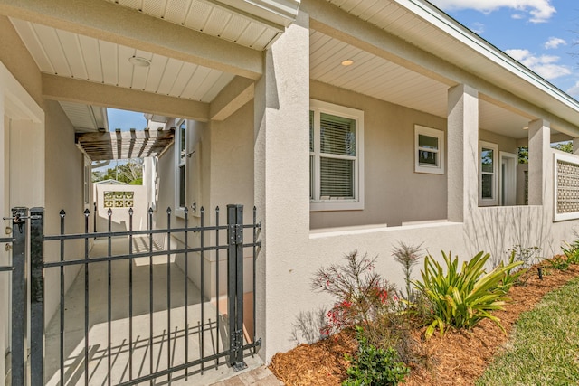 property entrance featuring a gate and stucco siding