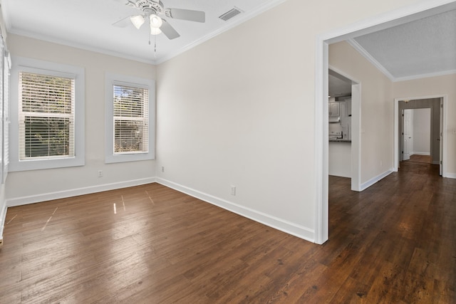 spare room with ornamental molding, baseboards, visible vents, and dark wood-type flooring