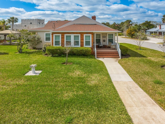 bungalow featuring covered porch, roof with shingles, a chimney, and a front yard