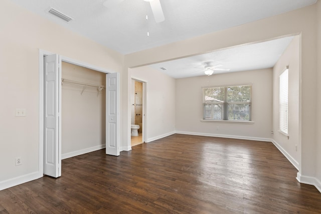 unfurnished bedroom with dark wood-type flooring, visible vents, ceiling fan, and baseboards