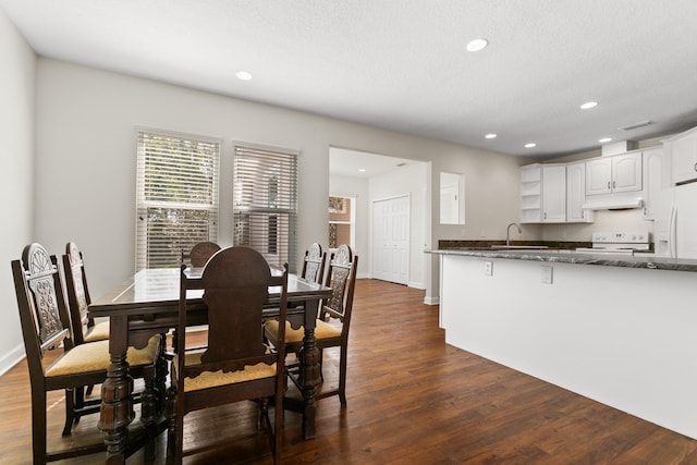 dining area featuring dark wood-type flooring, recessed lighting, a textured ceiling, and baseboards