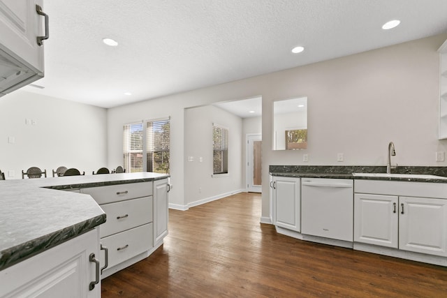 kitchen featuring white dishwasher, white cabinetry, dark wood finished floors, and a sink