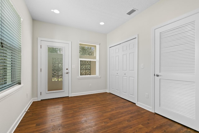 entryway featuring dark wood-type flooring, recessed lighting, visible vents, and baseboards