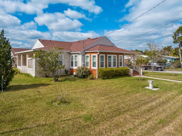 view of front of house with brick siding, a front lawn, and stucco siding