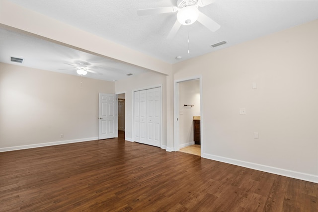 unfurnished room featuring a ceiling fan, baseboards, visible vents, and wood finished floors