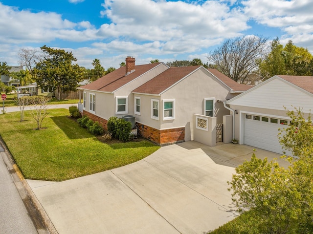 view of front of property with brick siding, a chimney, concrete driveway, central AC unit, and a front yard