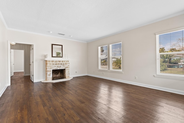 unfurnished living room featuring dark wood finished floors, a fireplace with raised hearth, visible vents, ornamental molding, and baseboards