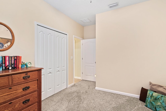 carpeted bedroom featuring a textured ceiling and a closet