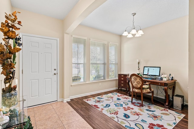 office area featuring beamed ceiling, a notable chandelier, and light hardwood / wood-style flooring