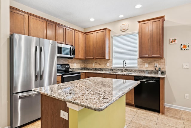 kitchen with a center island, sink, light stone counters, light tile patterned flooring, and black appliances