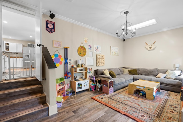 living room featuring dark wood-type flooring, crown molding, stairway, and an inviting chandelier