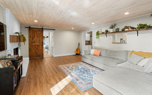 living area with recessed lighting, a barn door, wood ceiling, wood finished floors, and baseboards