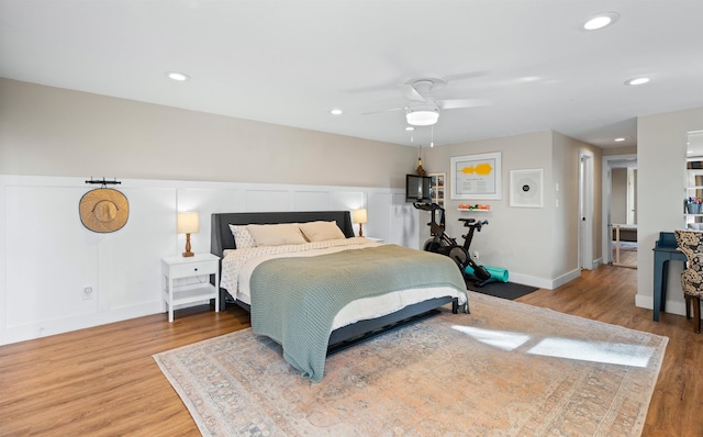 bedroom with a wainscoted wall, ceiling fan, light wood-type flooring, and recessed lighting