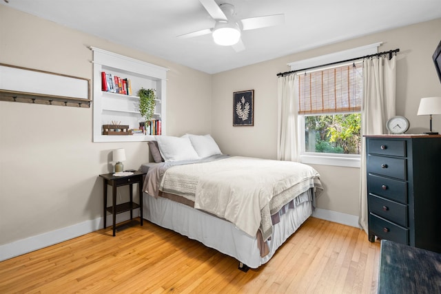 bedroom with light wood-type flooring, ceiling fan, and baseboards