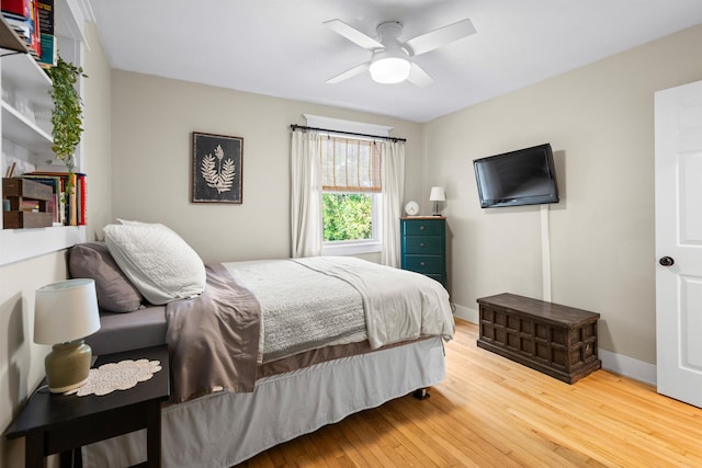 bedroom with a ceiling fan, baseboards, and hardwood / wood-style floors