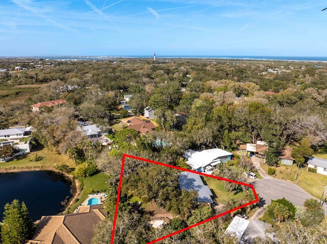 birds eye view of property featuring a water view and a view of trees