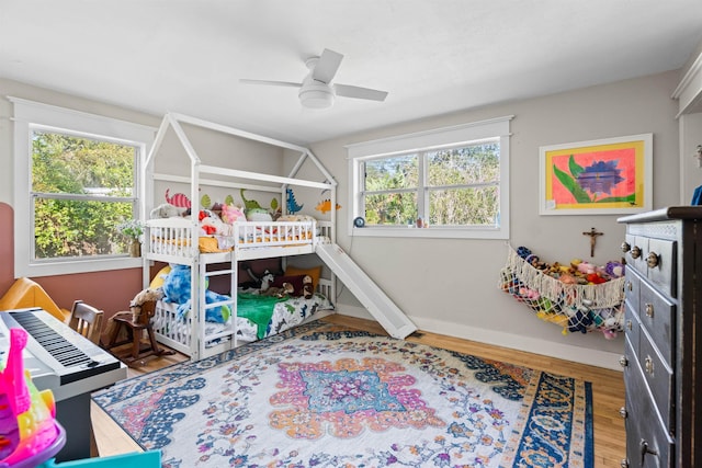 bedroom featuring ceiling fan, baseboards, and wood finished floors