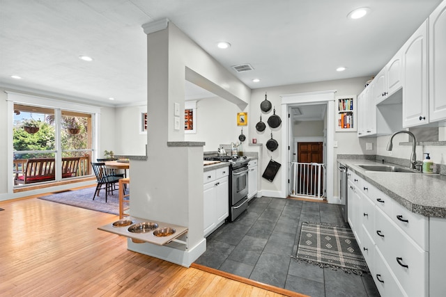 kitchen featuring visible vents, white cabinets, appliances with stainless steel finishes, a sink, and recessed lighting