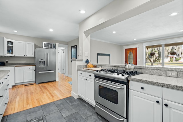 kitchen featuring stainless steel appliances, recessed lighting, white cabinets, and glass insert cabinets