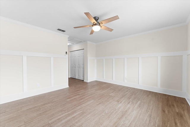 3385 Coastal Hwy Unit 23, Saint Augustine, FL 32084 - spare room featuring light wood-style flooring, ceiling fan, crown molding, attic access, and a decorative wall
